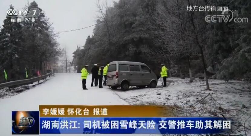 司機(jī)被困雪峰天險(xiǎn) 交警推車助其解困