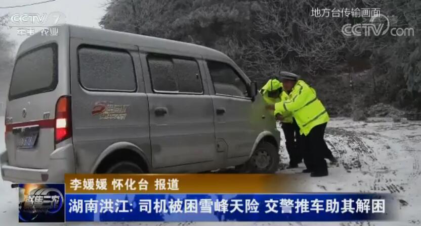 司機(jī)被困雪峰天險(xiǎn) 交警推車助其解困